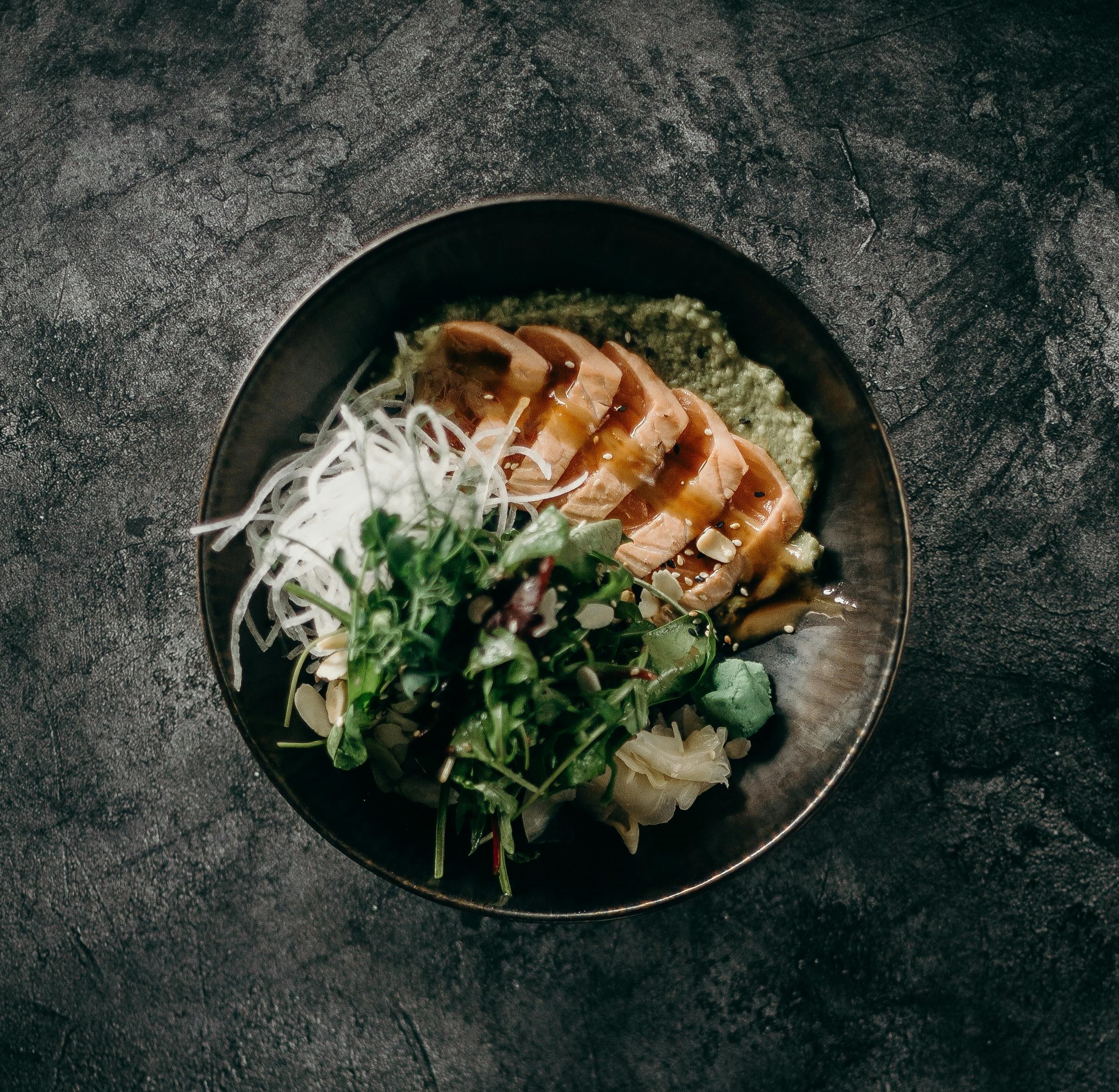 Seared salmon over vegetables and noodles
